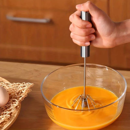 Push-button whisk showing stainless steel balloon head – one-hand kitchen tool