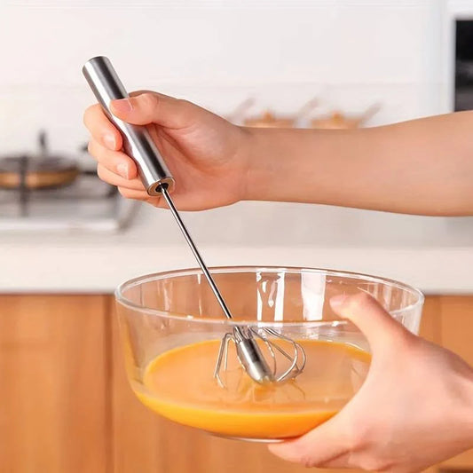 Semi-automatic stainless steel whisk in use whisking eggs in a bowl