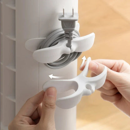 Four SecureCable clips in different colours on a white wall – home cable management