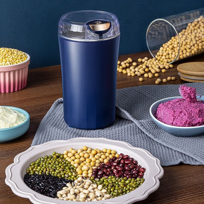Electric coffee grinder on a kitchen counter beside a bag of coffee beans
